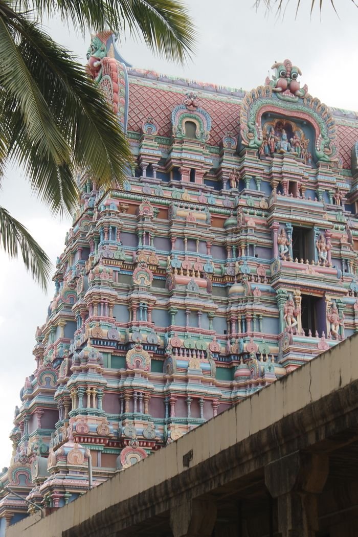 Colorful gopuram of Dravidian temple with intricate carvings, captured outdoors.